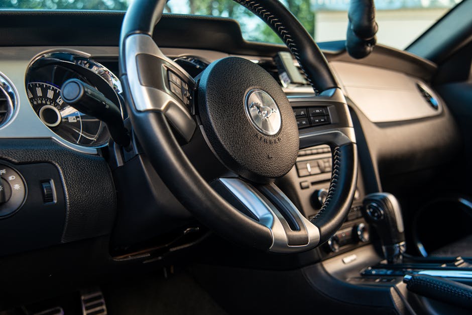 Interior view of a Ford Mustang featuring a luxury dashboard and iconic steering wheel, capturing the essence of a muscle car.